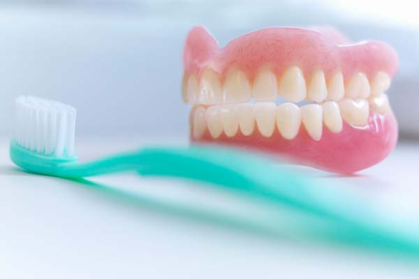 brush the denture with warm soapy water twice a day